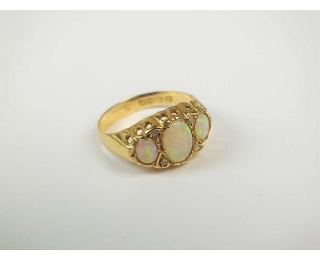 An early 20th century 18ct gold opal and diamond ring, designed as three graduated oval cabochon opals interspersed with four