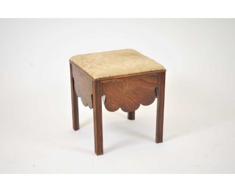 A George II mahogany veneered commode stool, with a hinged seat covered in a damask, above a shaped apron on each side, on sq