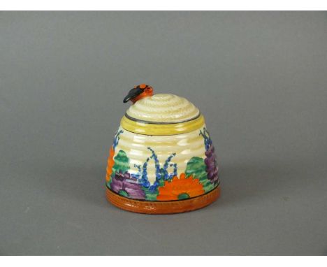 A Clarice Cliff Bizarre 'Gay Day' honey pot jar and cover circa 1930 the pot of ribbed beehive form, the lid with spoon cutou
