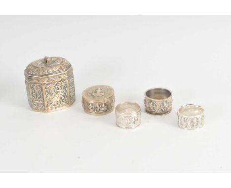 An Indian white metal tea caddy, with chased panel decoration depicting animals and trees, the hinged cover with elephant fin