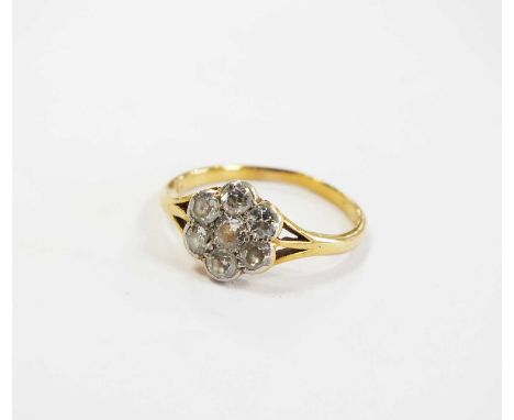 An early 20th century seven stone diamond floral cluster ring, the transition cut diamonds claw and collet set in white metal
