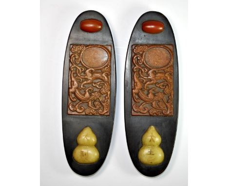 A pair of mid 20th century Chinese black hardwood scroll weights inset with carved semi-precious stones, L. 22.5cm.