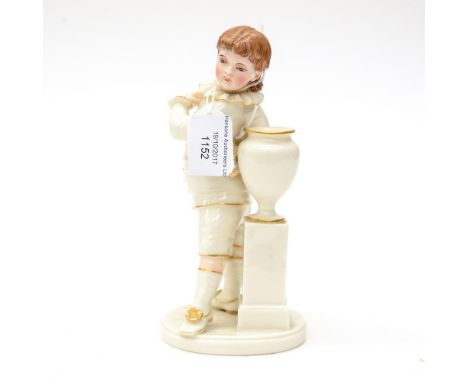 A Royal Worcester figure of a boy standing next to an urn, modelled by James Hadley, ivory glaze, highlighted in gilt with pa