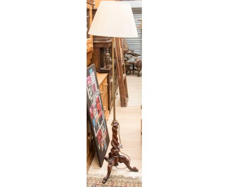 A standard lamp on mahogany tripod base with twisted brass column 