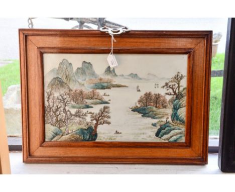A framed Chinese ceramic plaque, handpainted with mountains and lake scene, measuring approx 26cm x 41cm