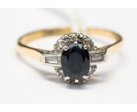 A sapphire and diamond 18ct yellow gold and platinum set fancy cluster ring, the centre sapphire measuring approx 6.5mm by 4.