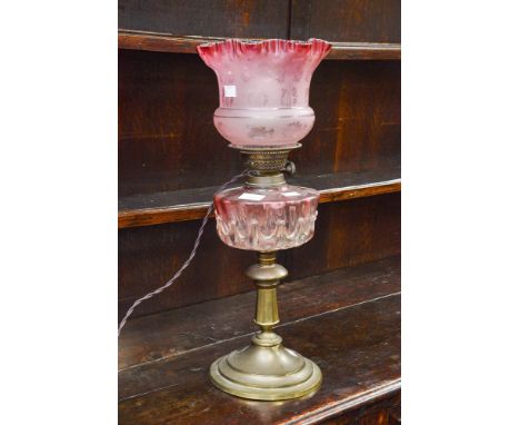 A converted Cranberry glass and brass oil lamp