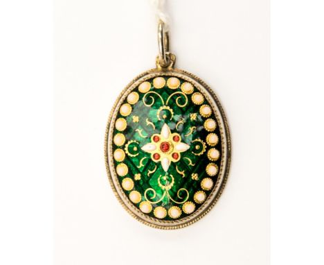A green enamel and paste set pendant, in yellow metal, with a flower detail to the centre with red paste dots, and a faux pea