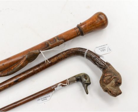 A walking stick carved with a snake; together with another carved with a dogs head handle and a silver collared cane with a d