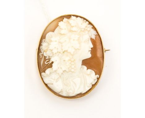 A Victorian oval shell cameo 9ct yellow gold brooch, the Baccanalian portrait with fruit vine and leaf decoration to hair, 9c
