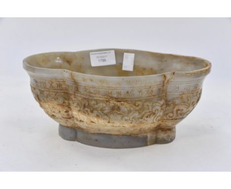 An oval soap stone style bowl, being carved to the sides with Chinese script and scroll decoration