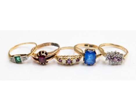 A group of five 9ct gold dress rings, comprising an emerald and diamond set ring, an amethyst and opal boat ring a garnet sin