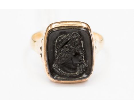 A gold ring inset with carved onyx set in yellow metal probably 18ct. Ring size P, with a total gross weight of approx 4.1gms