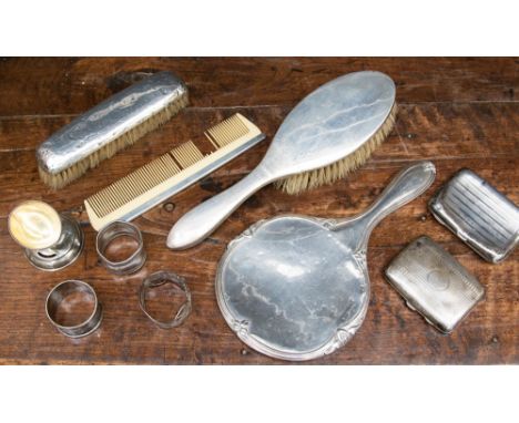 A collection of silver items including two hallmarked silver card cases, napkin rings, unmatched dressing table set, etc (one