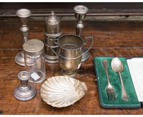 A group of silver items to include a shell bon bon dish, three silver candlesticks (two matching), a sugar sifter, a silver t