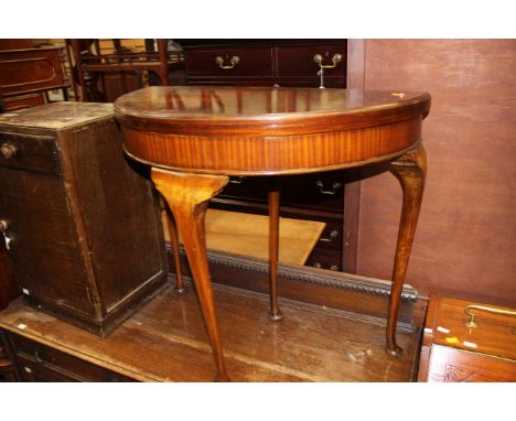 An early 20th Century mahogany fold over card table, of Demilune form, raised on cabriole legs