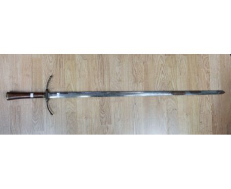 A large Crusader style sword. Wooden grip with brass pommel and crossguard. 103 cm long double edge blade with some rust patc