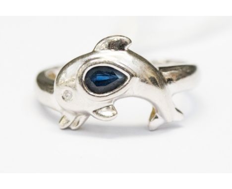 A sapphire platinum ring in the form of a dolphin, the pear shaped sapphire set to the body with a small diamond set eye, rin