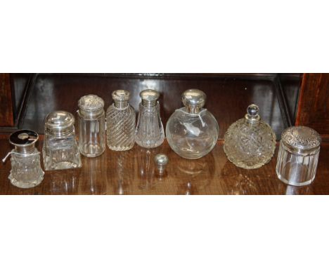 Collection of eight Silver Topped Cut Glass Dressing Table Bottles including: Fluted shaped glass with silver top and origina