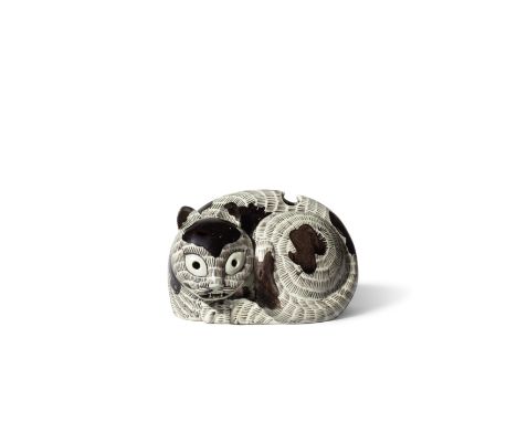 A RARE BROWN-ENAMELLED RECUMBENT 'CAT' NIGHT LIGHTKangxi Amusingly potted tightly crouching looking to its left with tail cur