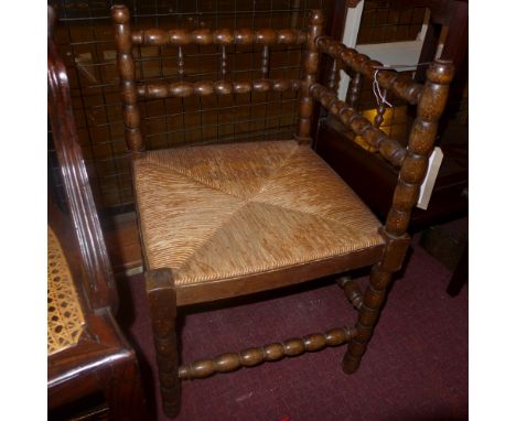 A pair of oak bobbin turned corner chairs with rush seats