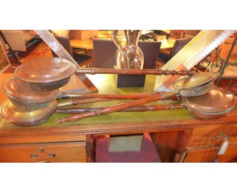 A collection of brass and copper warming pans and a tapestry fire screen 