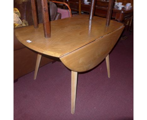 A 1960s Ercol light elm dining table with twin flaps raised on tapering supports