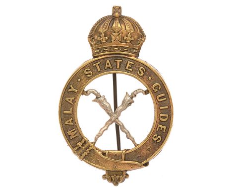 Malay States Guides pagri badge.  Good scarce British made die-stamped brass crowned title strap; white metal crossed kris to
