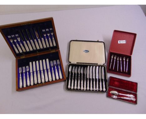 A cased set of fruit knives and forks with silver handles, silver cocktail forks, cased silver spoon and fork and a set of tw
