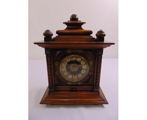An oak cased French mantle chiming clock with gilt and enamel decoration on stepped square base