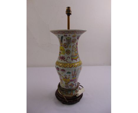 An early Chinese porcelain table lamp decorated with stylised leaves and furniture on carved hardwood stand