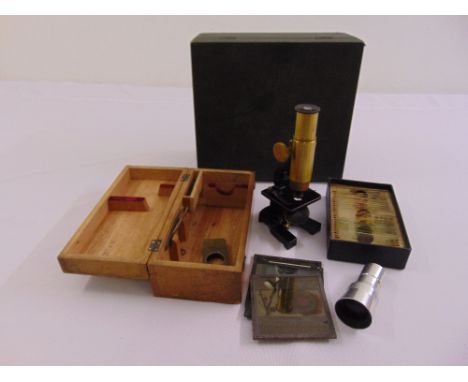 A travelling brass microscope in fitted case, approx 20 prepared slides and magic lantern slides