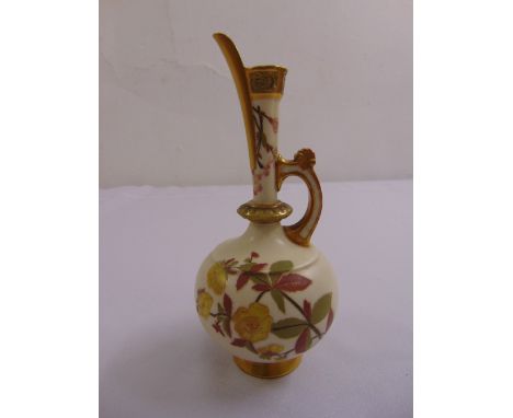 A Royal Worcester decorative jug with floral designs to the side and gilded mounts