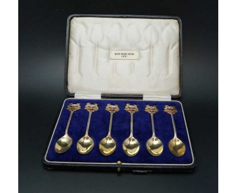 Sydney &amp; Co. A cased set of six silver gilt &amp; enamel commemorative tea spoons, the terminal fashioned as the crest of