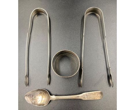 A selection of four silver items to include two sugar nips, napkin ring and a teaspoon