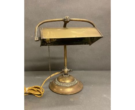 An antique brass bankers lamp with adjustable shade 