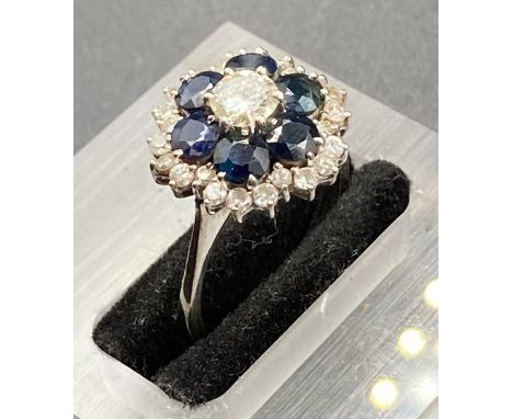 A diamond and sapphire cluster ring, on 18k white gold.