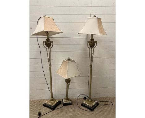 A pair of contemporary floor lamps and a matching table lamp with urn details 