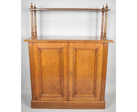 An Edwardian Oak Side Cupboard with Raised Shelf on Four Turned Supports, Panelled Doors to Shelved Interior, 100cm wide 
