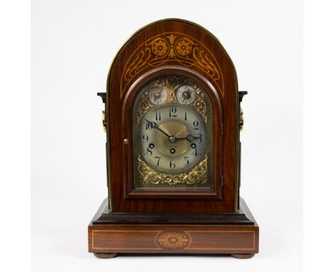 An English table clock in veneered wood, decorated with inlaid motifs. Early twentieth century.Een Engelse tafelklok van gefi