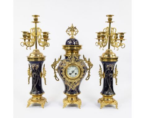 Three piece faience garnish decorated with stylized whiplash motifs and gilt brass, candlesticks with 5 light points, ca 1900