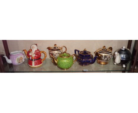 Shelf of teapots inc. an Art Deco Heatmaster, and a Sadler Father Christmas teapot