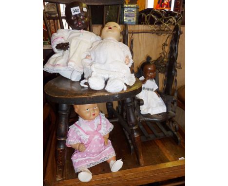 Four vintage dolls with composition heads (2 black and 2 white) and a dolls swing chair