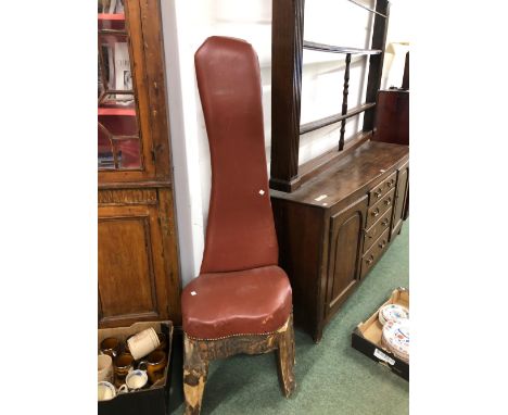 A TALL BACKED CHAIR CUT FROM A TREE TRUNK, THE SEAT AND BACK COVERED IN BROWN LEATHER