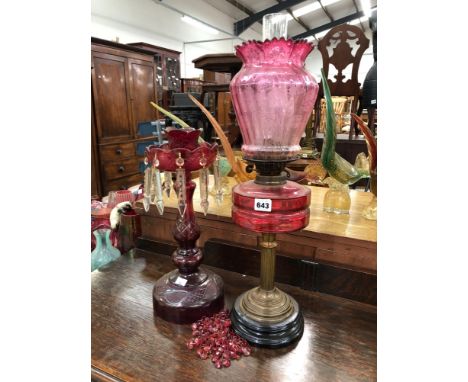 A VICTORIAN CRANBERRY GLASS OIL LAMP AND SHADE AND A SIMILAR CUT GLASSED LUSTER