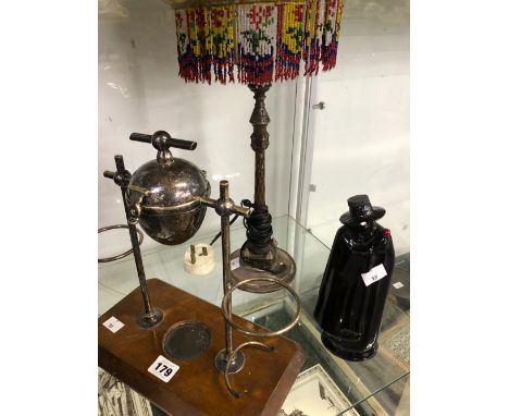 AN ELECTROPLATE FRUIT SQUEEZER ON STAND, A WADE ZORRO BOTTLE AND A TABLE LAMP