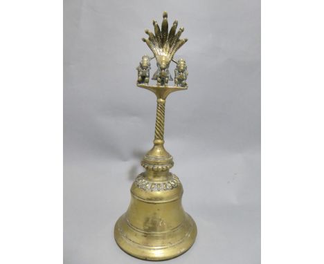 A C19th Indian brass temple prayer bell with three figures on the handle below fan on twisted support
