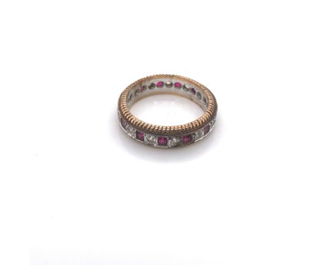 A 9ct YELLOW AND WHITE GOLD HALLMARKED SYNTHETIC SPINEL AND RUBY FULL ETERNITY RING. DATED 1986, BIRMINGHAM. FINGER SIZE R. W