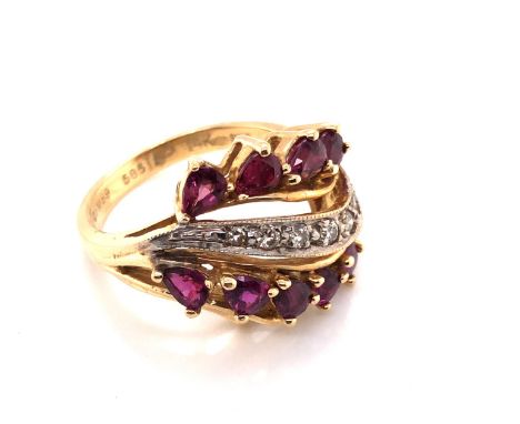 A RUBY AND DIAMOND DRESS RING. TEN PEAR CUT RUBIES FRAME A GRAIN SET WAVE OF DIAMONDS. APPROX RUBY TOTAL WEIGHT 1.60ct, DIAMO