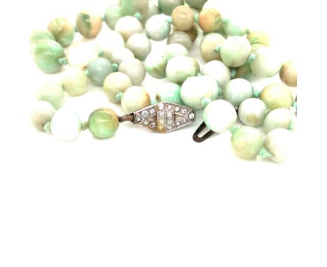 A STRAND OF GRADUATED JADE BEADS COMPLETE WITH A SILVER AND PASTE STONE CLASP. BEAD GRADUATION 8mm to 11mm. LENGTH 74cms .PLE